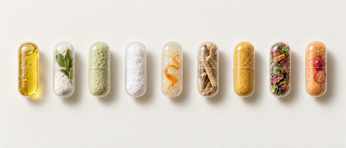 Nine clear capsules in a row on a cream background